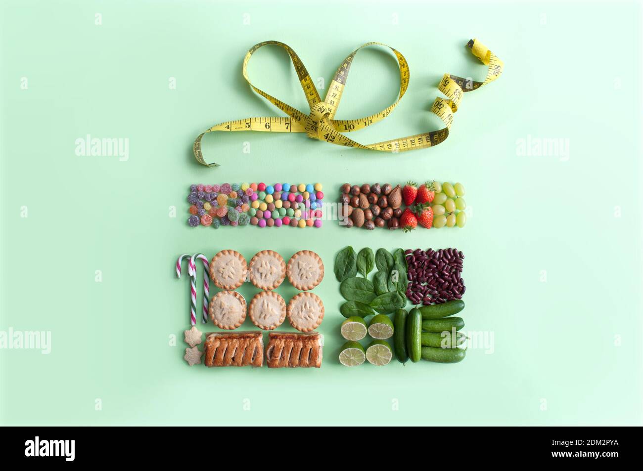 Cibo sano e dieta di natale fianco a fianco in un confezione regalo con archetto per metro a nastro Foto Stock