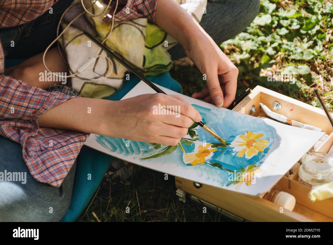 Closeup delle mani della donna che pitano in oli fiori luminosi all'aperto, concetto plein-air Foto Stock