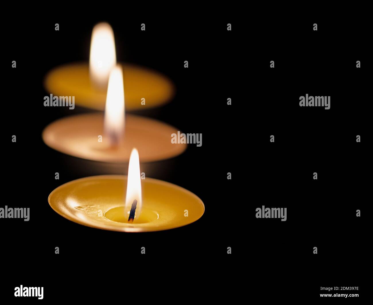 Tre luci per il tè su sfondo nero Foto Stock