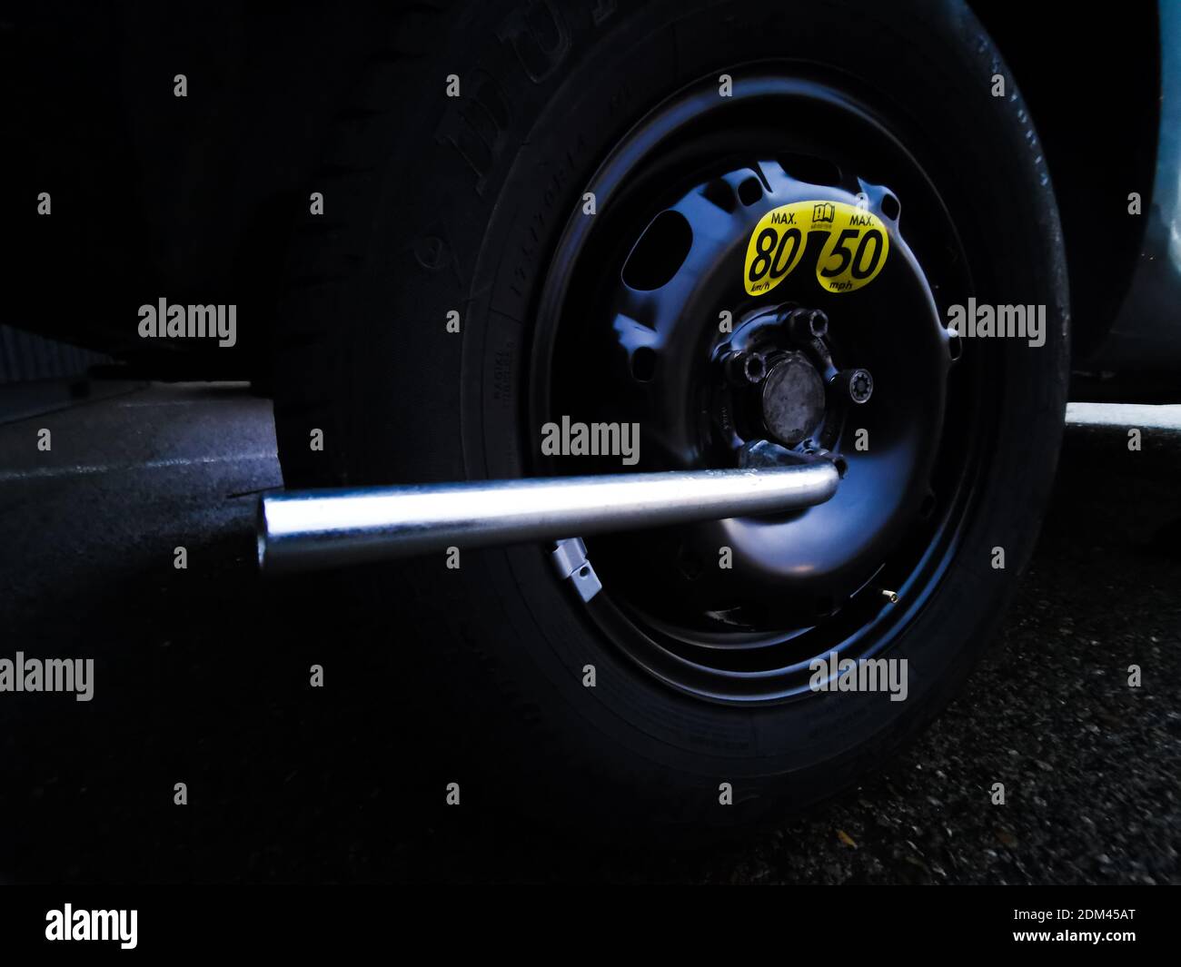 Ruota di scorta montata su un'auto dopo una foratura dello pneumatico originale. La velocità massima consentita per la vettura viene indicata sullo pneumatico. Foto Stock