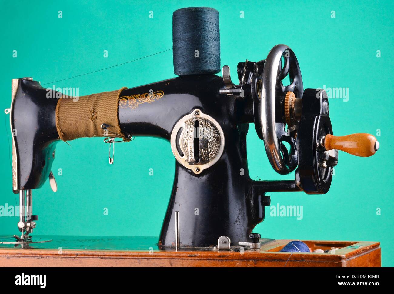 Antica macchina da cucire vintage isolata su sfondo color pastello verde menta Foto Stock