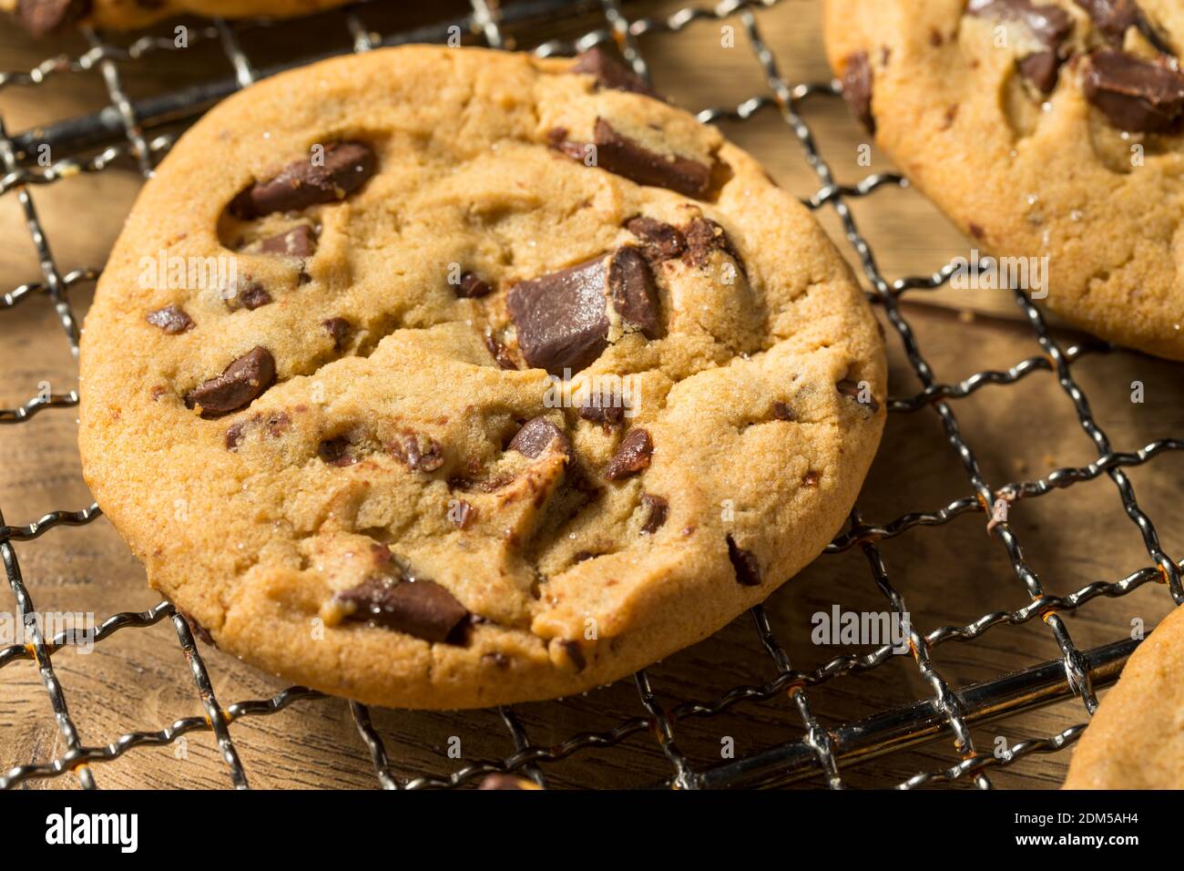 Biscotti caldi fatti in casa con chip di cioccolato su un rack di raffreddamento Foto Stock