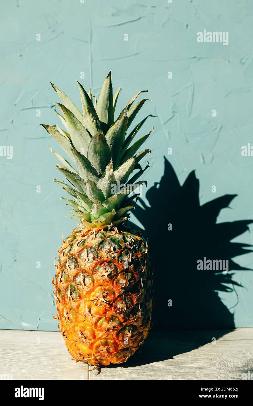 Grande ananas maturo con un'ombra, copia spazio su sfondo di legno in tema tropicale Foto Stock