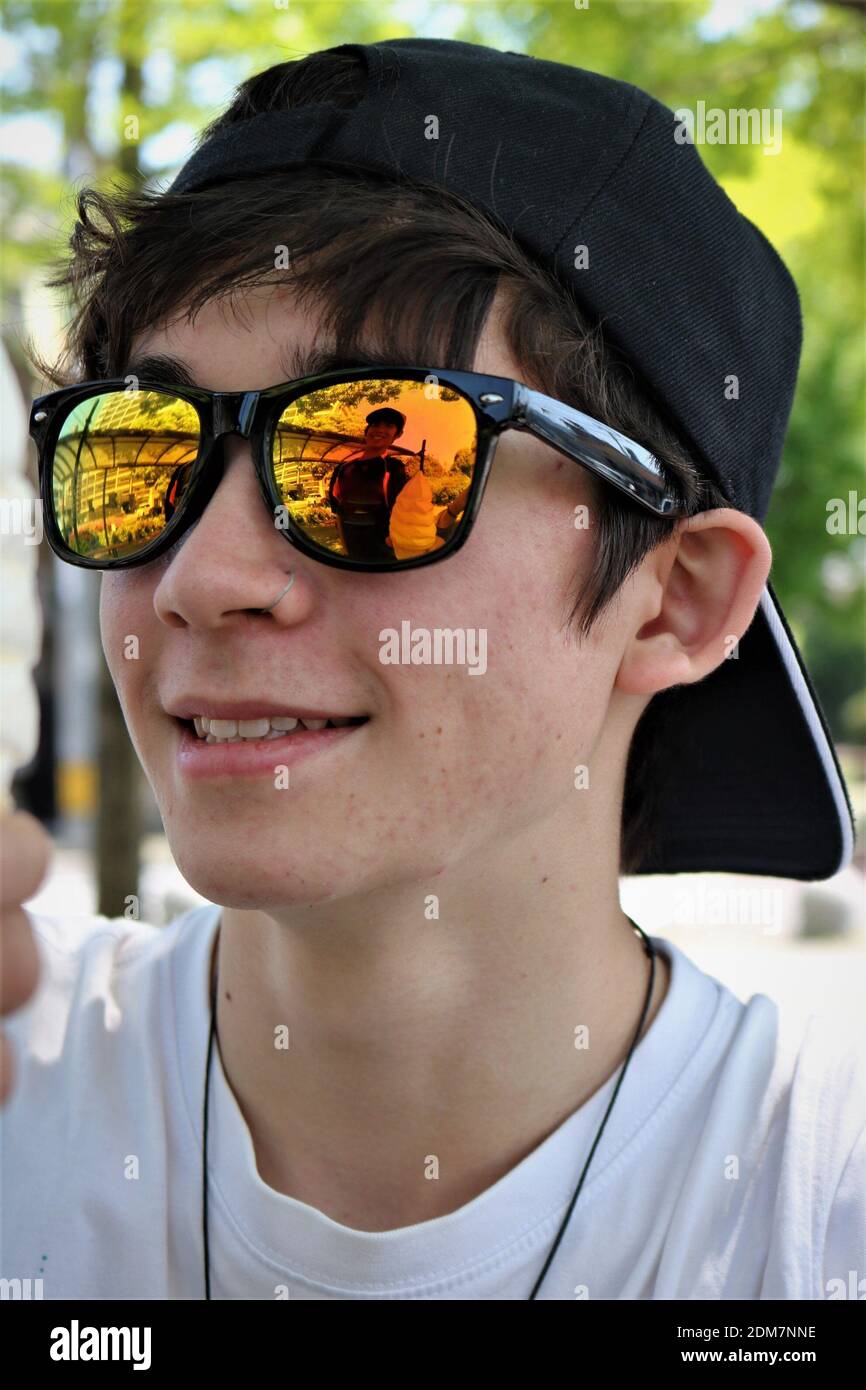 Giovane uomo che indossa occhiali da sole e anello naso Foto stock - Alamy