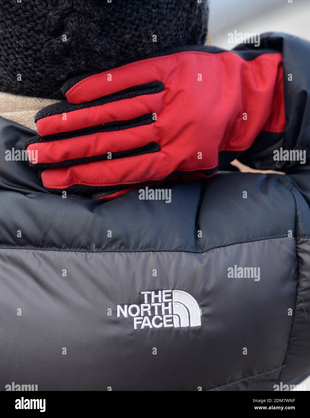 Una donna indossa guanti e una giacca invernale acquistata presso il  negozio di abbigliamento North Face Foto stock - Alamy