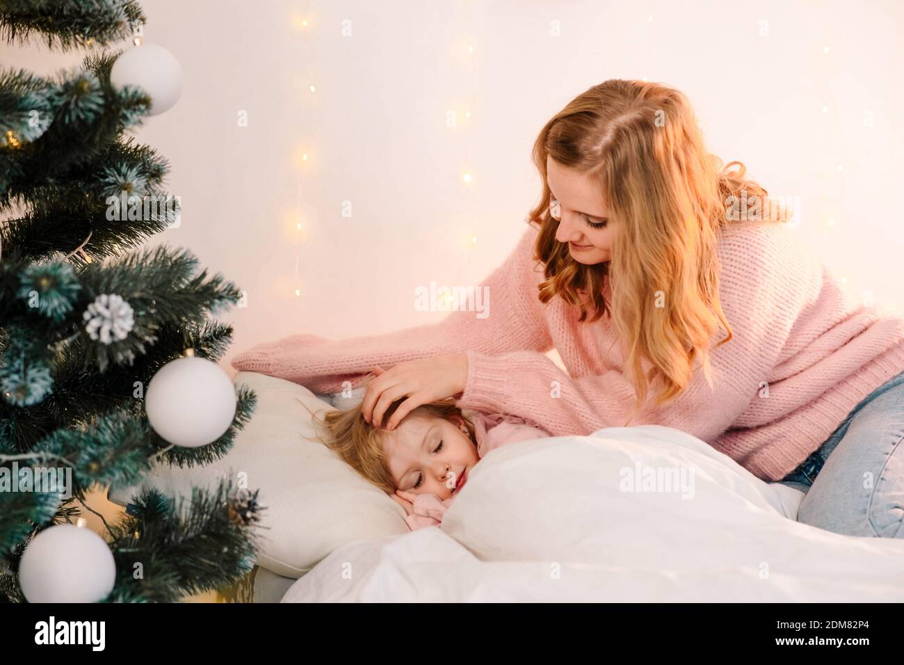 Mamma carezza la figlia addormentata Foto Stock