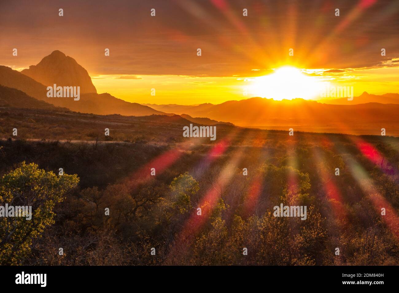 Il sole tramonta sotto lo strato di nube per illuminare la Santa Cruz Valley (a sud di Tucson) e Elephant Head nelle montagne di Santa Rita. Foto Stock
