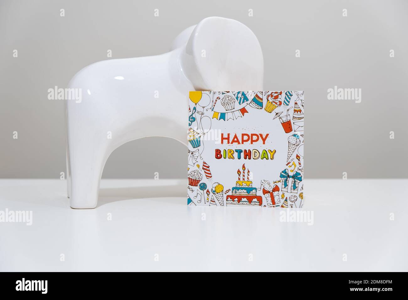 Biglietto di compleanno e oggetto elefante. Concetto di festa di compleanno. Composizione creativa fatta di oggetto elefante e carta di compleanno. Foto Stock