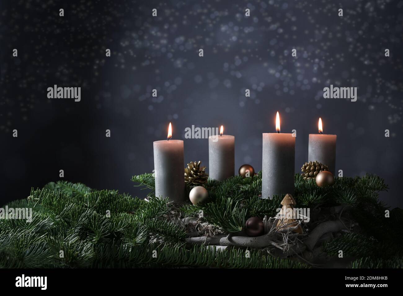 Quarto avvento con quattro candele brucianti su rami di abete con decorazione di Natale contro uno sfondo grigio scuro, spazio di copia, fuoco selezionato, stretto d Foto Stock