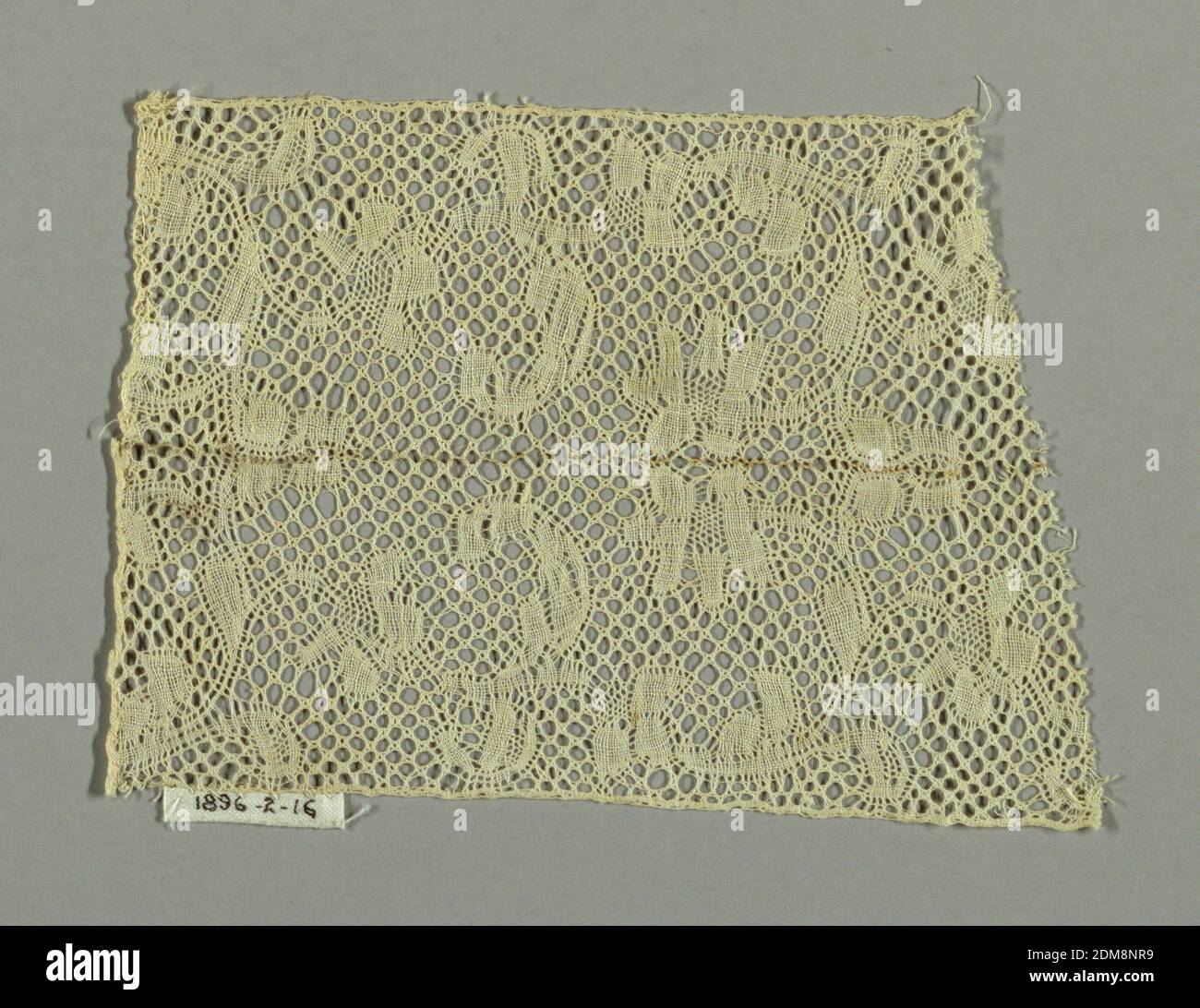 Fragment, Medium: linen tecnica: Bobbin Lace (stile Binche con Binche Ground), frammento in stile Binche con un disegno di bordo di rami fioriti che si incurvano su e indietro dal bordo del pezzo. Massa trio Cinq. Disegno ripetuto in senso inverso nella metà superiore del pezzo. Frammento è due pezzi cuciti insieme nel mezzo., Belgio, 17 ° secolo, merletto, frammento Foto Stock
