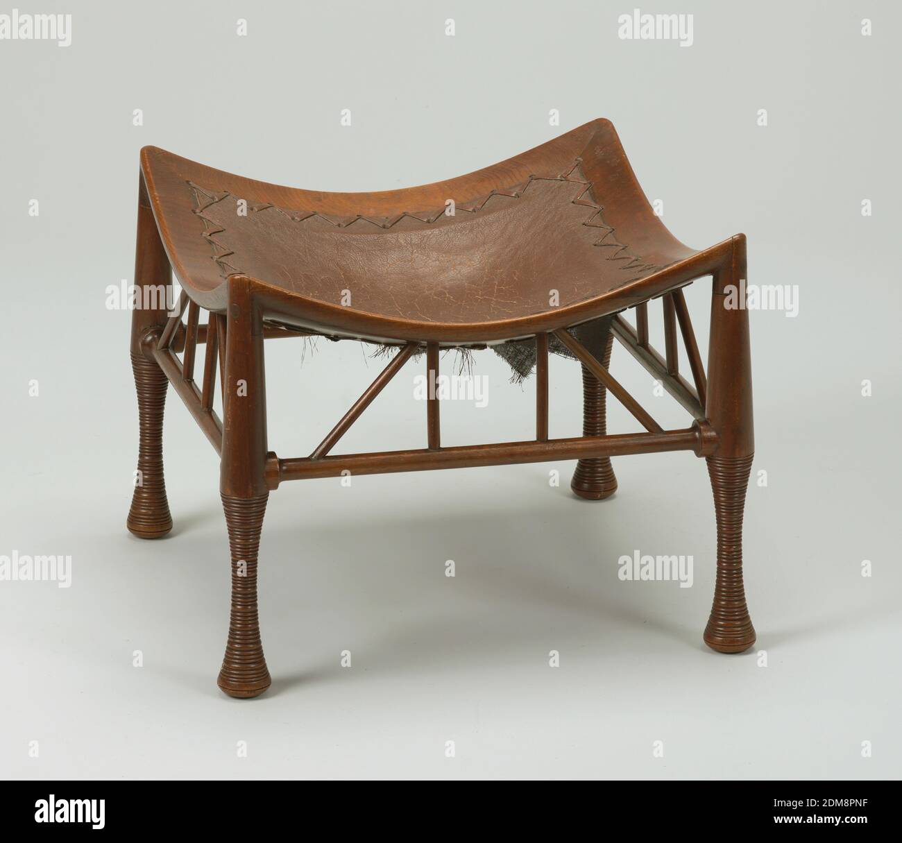 Tebe, Mahogany, cuoio, quadrato, seduta in pelle marrone concava in struttura di legno con gambe cilindriche rastremate unite da barelle orizzontali e tasselli angolati., Inghilterra, ca. 1884, Mobili, Arti decorative, Sgabello, Sgabello Foto Stock