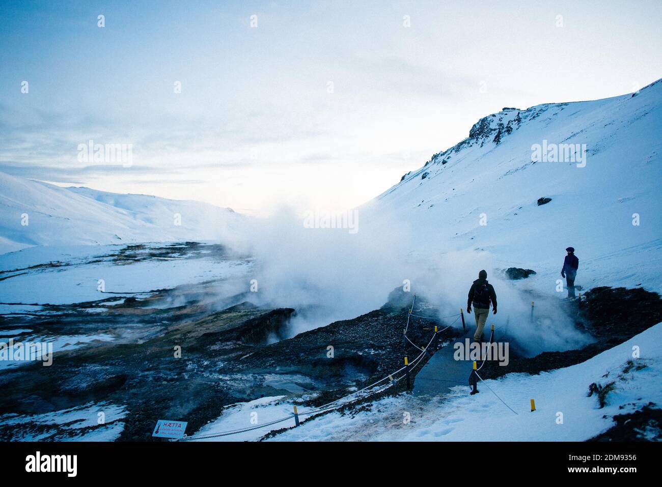 Due persone che camminano attraverso le piscine geotermiche al fiume reykjadalur Foto Stock