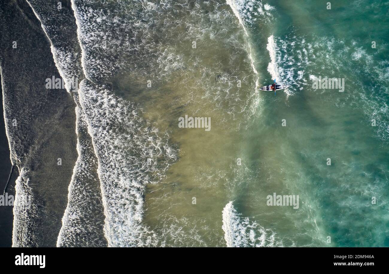 Vista dall'alto di una persona in kayak che galleggia sulle onde Dell'oceano Atlantico con schiuma in Islanda Foto Stock