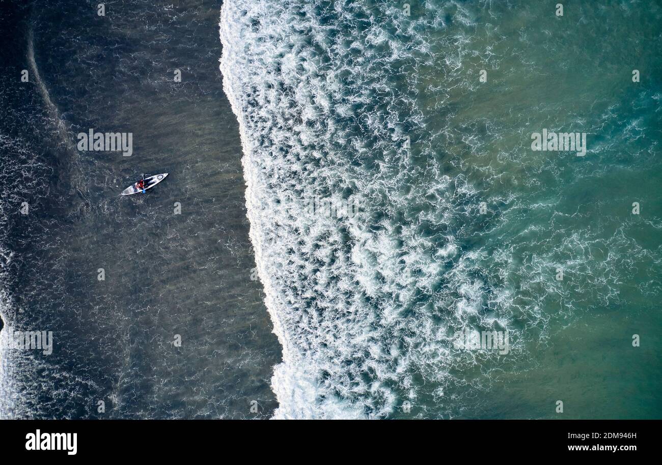 Vista sul drone del kayak che galleggia su potenti onde di freddo Oceano Atlantico in Islanda Foto Stock