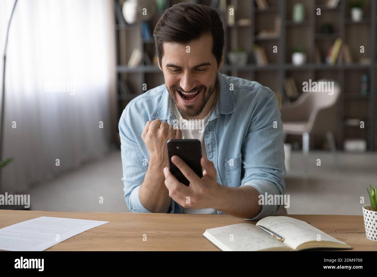 L'uomo sopravorato trionfa vincendo lotteria sul cellulare Foto Stock