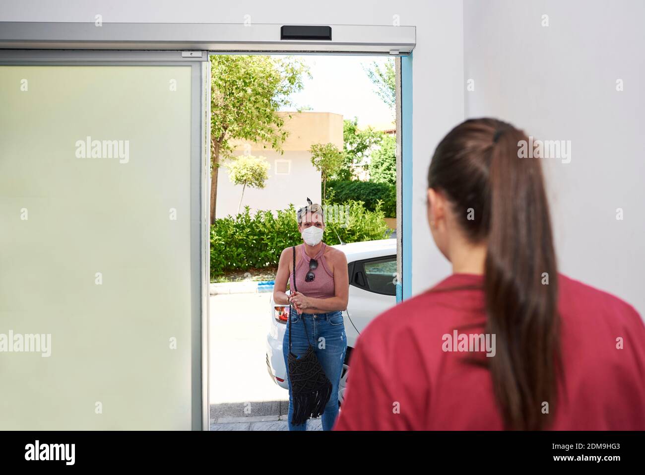 Fisioterapista riceve il suo cliente. Hanno misure di sicurezza contro il virus corona Foto Stock