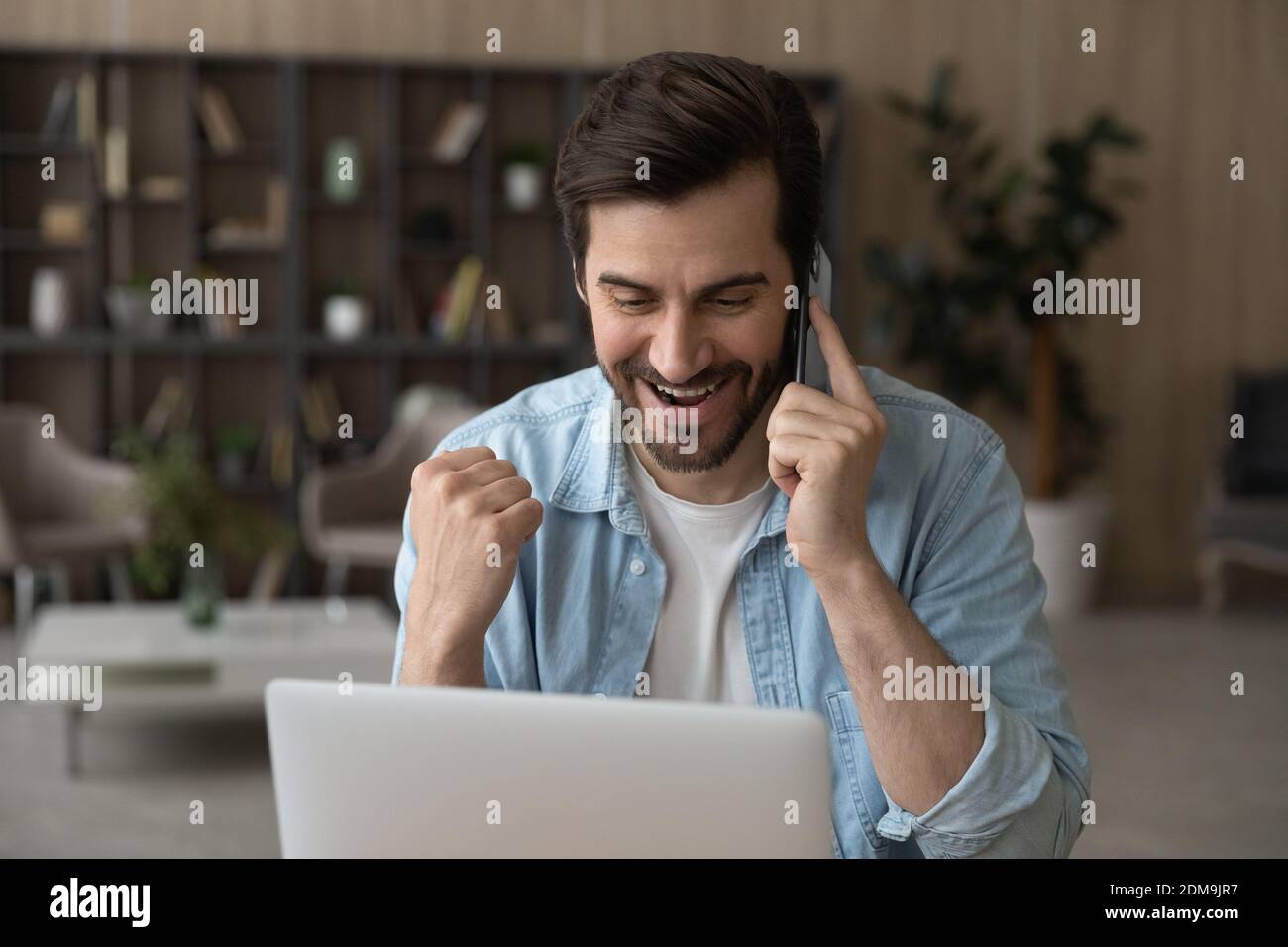 L'uomo molto gioioso parlare su cella celebrare la vittoria online Foto Stock