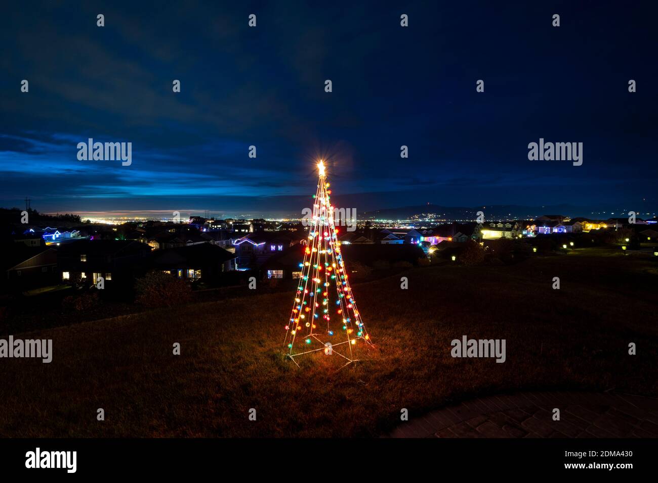 Un ornamento natalizio illuminato si trova su un patio collinare che si affaccia sulla Spokane Valley e sul centro cittadino nello Stato di Washington, Stati Uniti Foto Stock