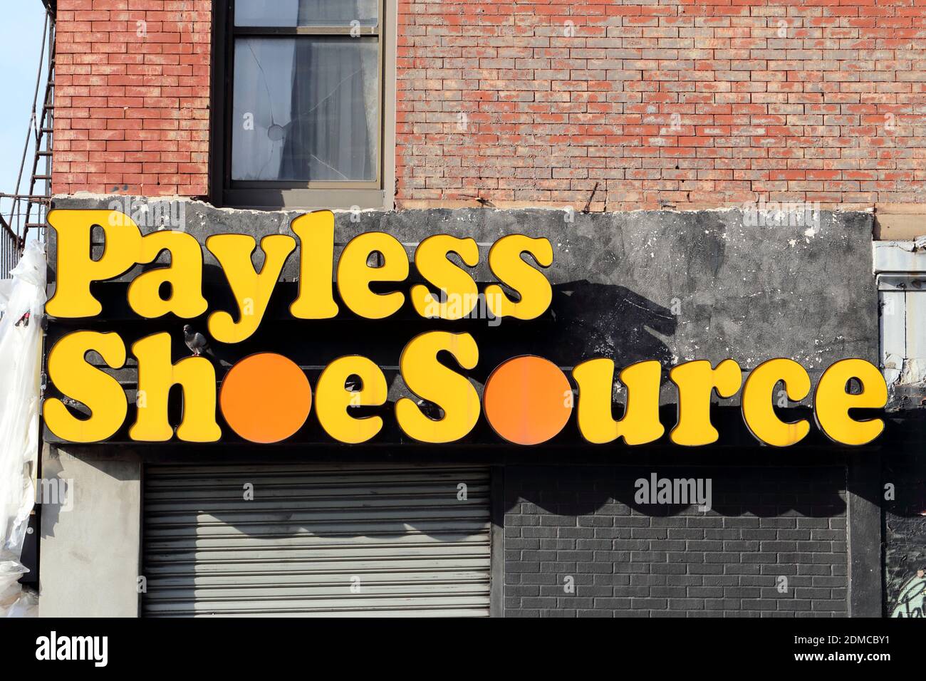 Il vecchio logo e la segnaletica di Payless ShoeSource su un edificio in mattoni Foto Stock