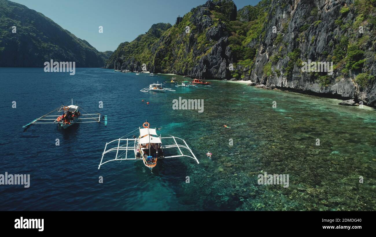 Closeup vacanze estive sulle barche passeggeri in oceano. Incredibile paesaggio di scogliera con verdi alberi tropicali giungla. Epico mare tropicale sull'isola di montagna di Palawan, Filippine, Asia Foto Stock