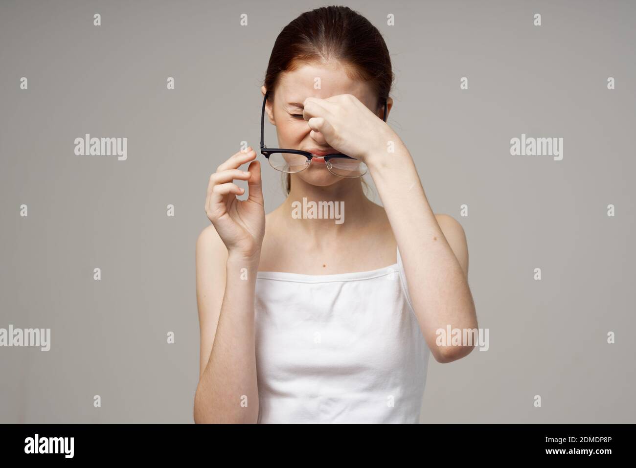 donna dai capelli rossi con occhiali problemi di vista affaticamento Foto Stock