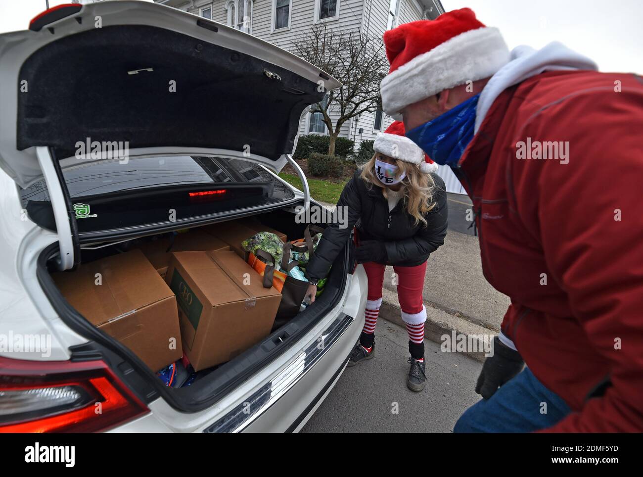 Kingston, Stati Uniti. 16 Dic 2020. I volontari hanno messo il cibo nel bagagliaio di un veicolo ad un azionamento senza tocco attraverso la dispensa del cibo.Sin dall'inizio di Covid la dispensa del cibo di al Beech è stata molto occupata, oggi hanno servito là un millionesimo ospite. Per i volontari di Natale indossavano cappelli Santa e consegnavano carte regalo, caramelle e palloncini insieme ai normali prodotti alimentari. Credit: SOPA Images Limited/Alamy Live News Foto Stock