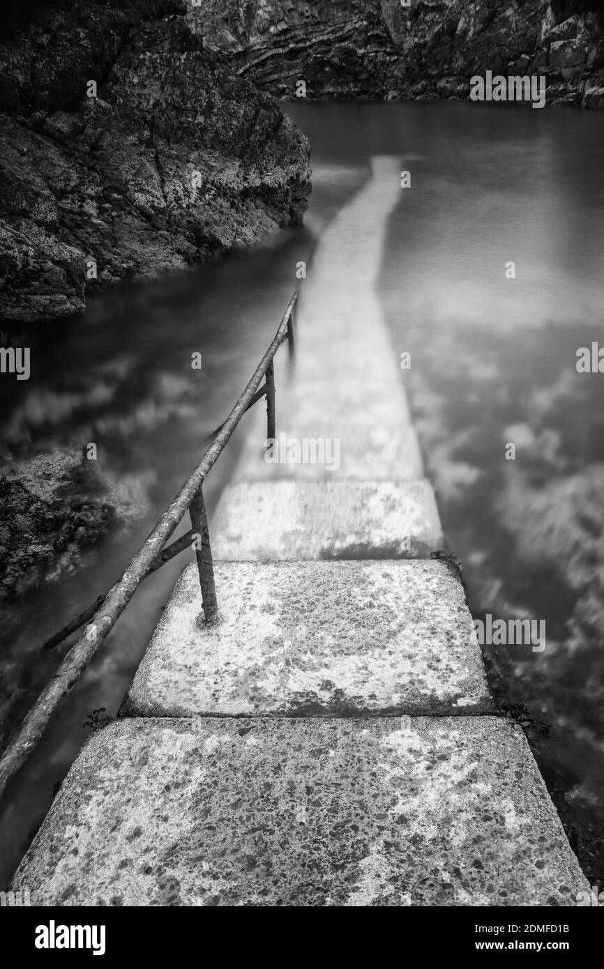 Un'immagine verticale di un vecchio ponte di pietra in scala di grigi Foto Stock