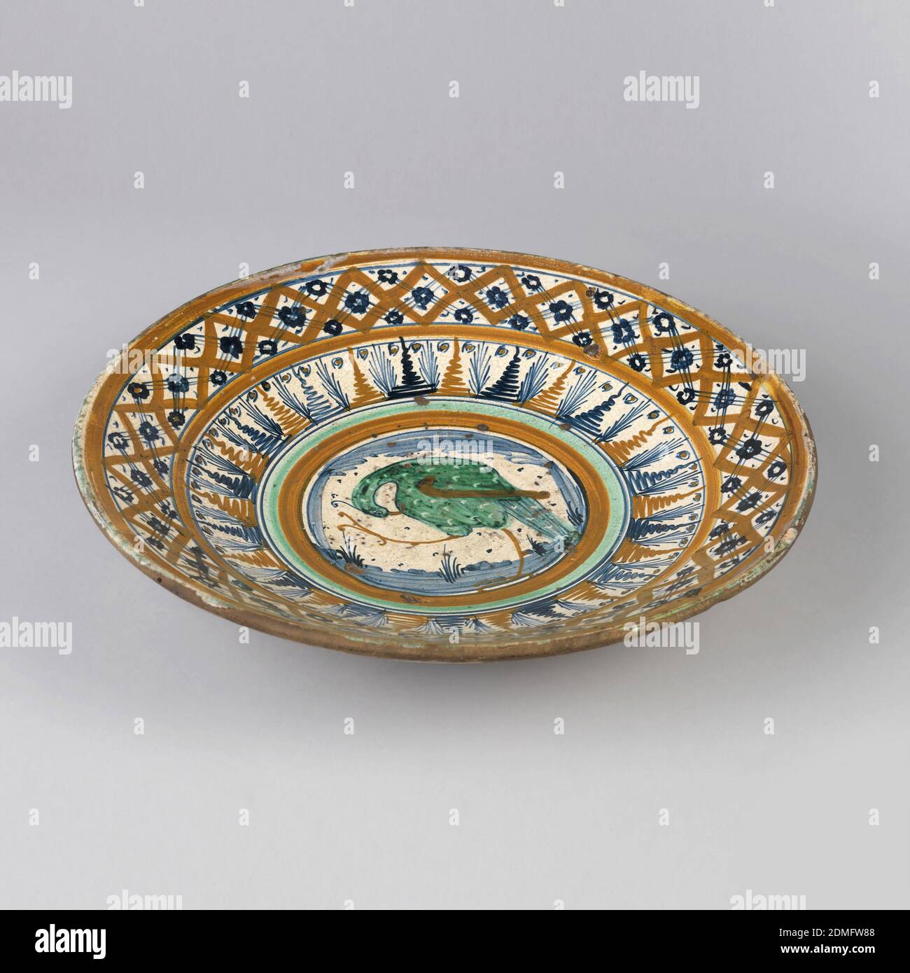 Piatto, in terracotta smaltata, a forma di Saucer, dipinto al centro con uccello verde entro i bordi arancione e verde e due bordi esterni in arancione e blu., Montelupo, Italia, ca. 1490–1520, ceramica, arti decorative, piatto Foto Stock