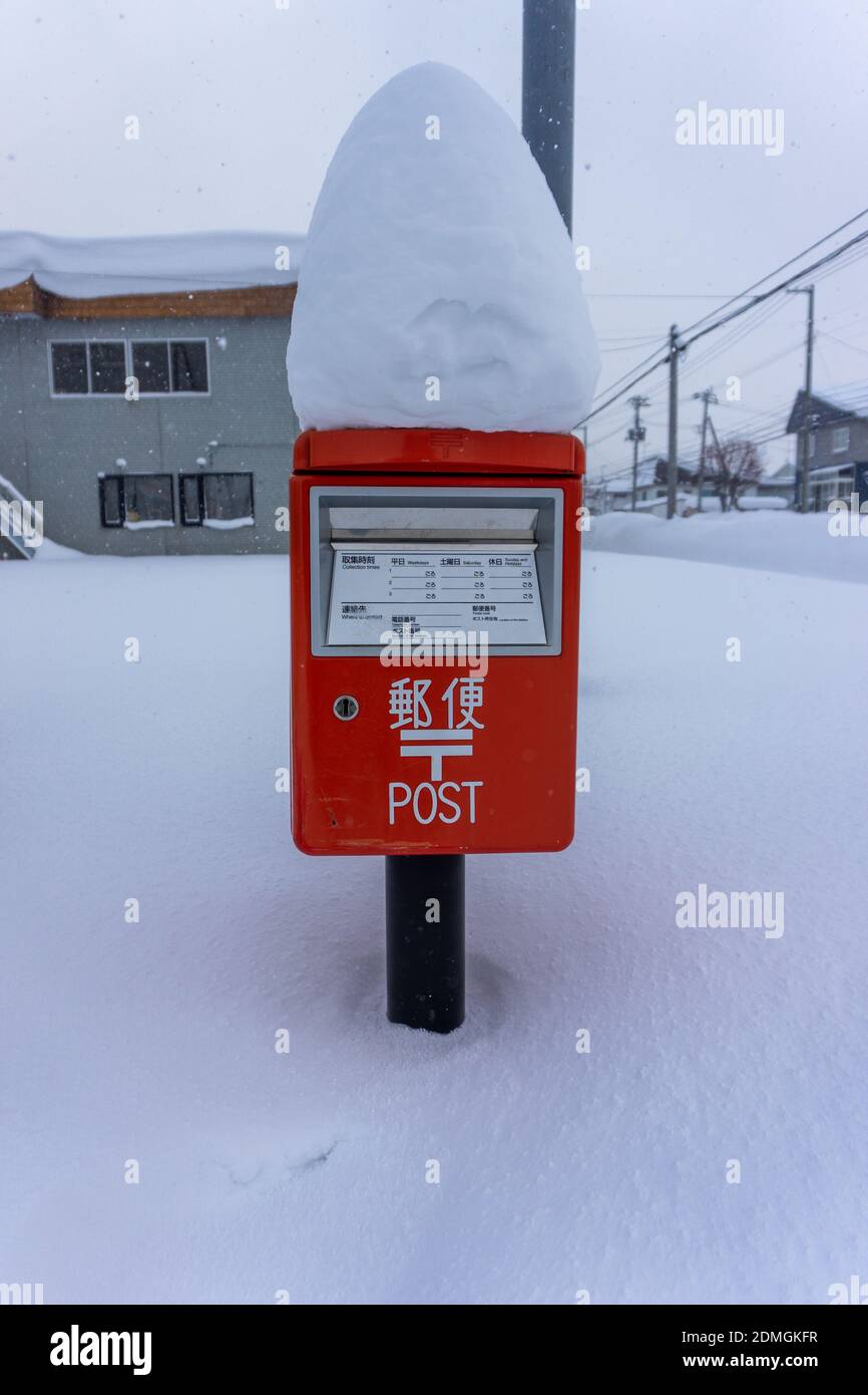 Casella postale coperta in un mucchio di neve fresca durante nevicate pesanti Foto Stock