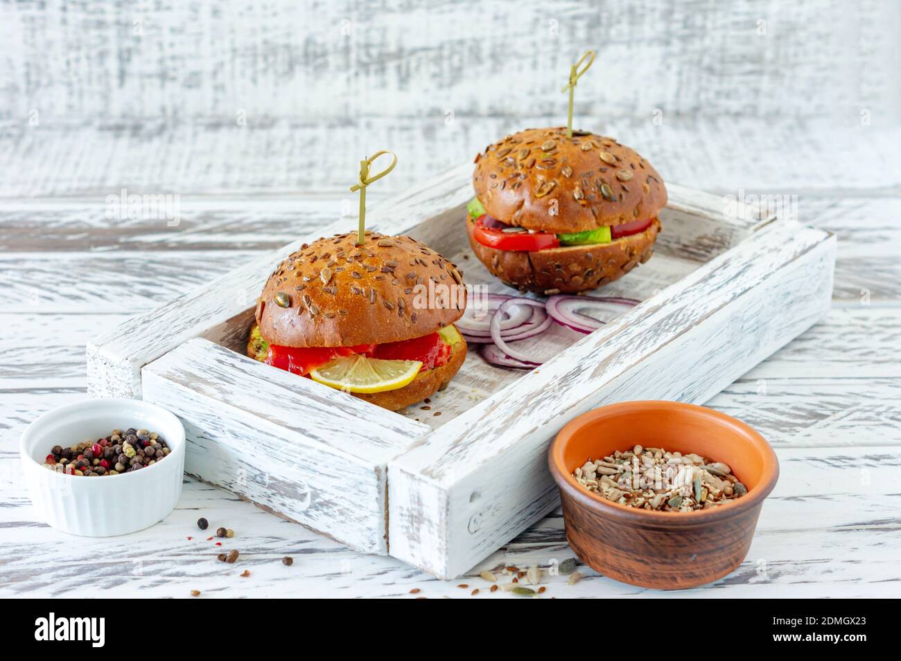 panino intero farcito con insalata, salmone, avocado e pomodori. Concetto di cibo sano. Foto Stock