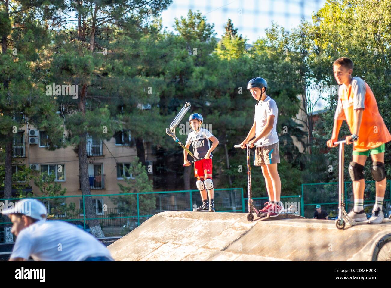 Anapa, Russia - 08.05.20: I ragazzi cavalcano skateboard e scooter sugli scivoli della città sportiva. Sport pericoloso. Foto Stock