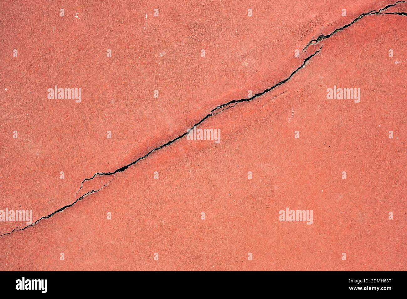 Crepa su uno sfondo rosso della vecchia parete esterna grunge Foto Stock