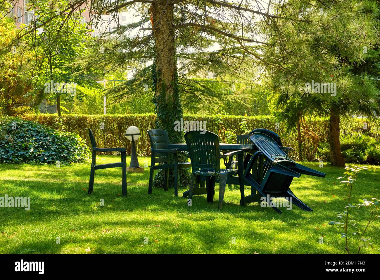Mobili da giardino in plastica verde con sedie e tavolo sul verde erba e  prato con alberi in una giornata di sole Foto stock - Alamy