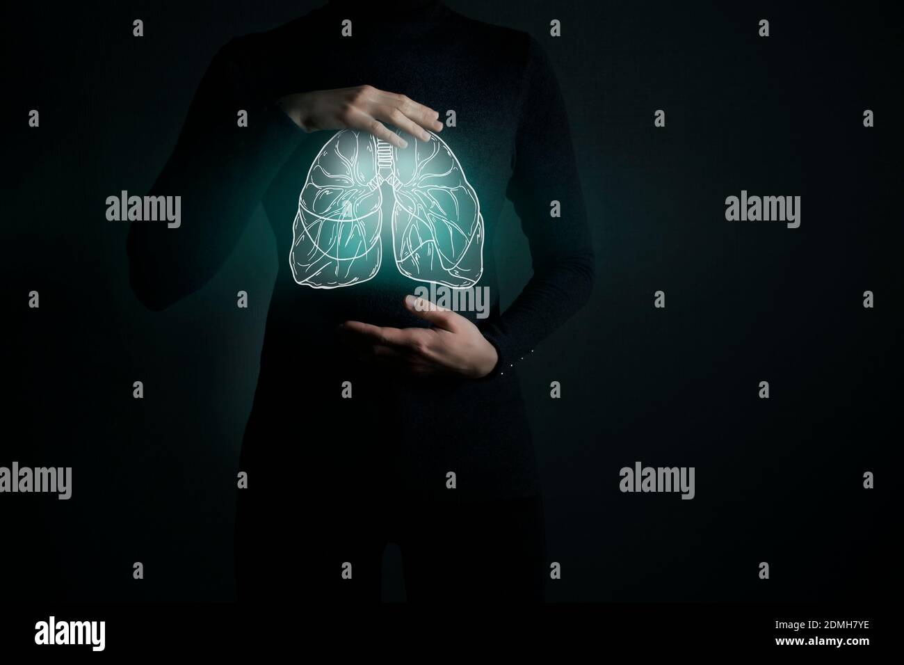 Illustrazione della detossazione dei polmoni con organo evidenziato e mani di contrasto su sfondo scuro. Foto chiave bassa con spazio per la copia tonato in colori verde scuro. Foto Stock