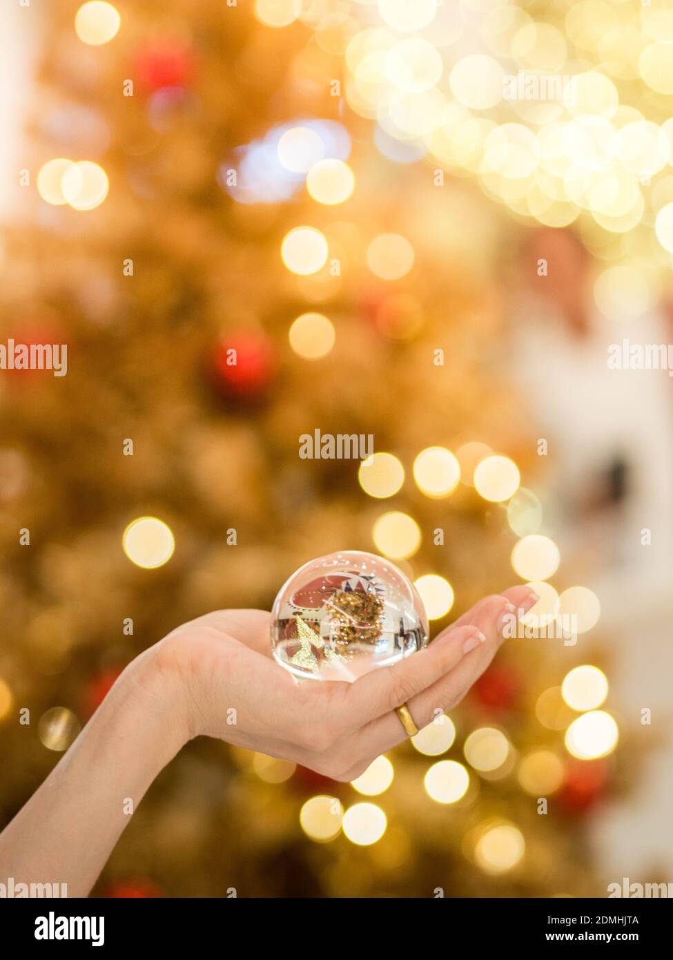 Ritagliato mano azienda sfera di cristallo illuminata contro l albero di  Natale Foto stock - Alamy