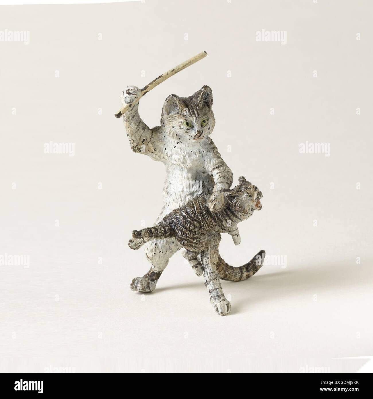 Gatto e gattino, ghisa e ottone verniciato, grigio, nero, e gatto tabby bianco in piedi sulle gambe posteriori tiene un bastone rialzato sopra un gattino di mwing che si trova attraverso il suo ginocchio, come se nell'atto di sculacciare., probabilmente Austria, fine del XIX-inizio del XX secolo, miniature, arti decorative, figura, figura Foto Stock