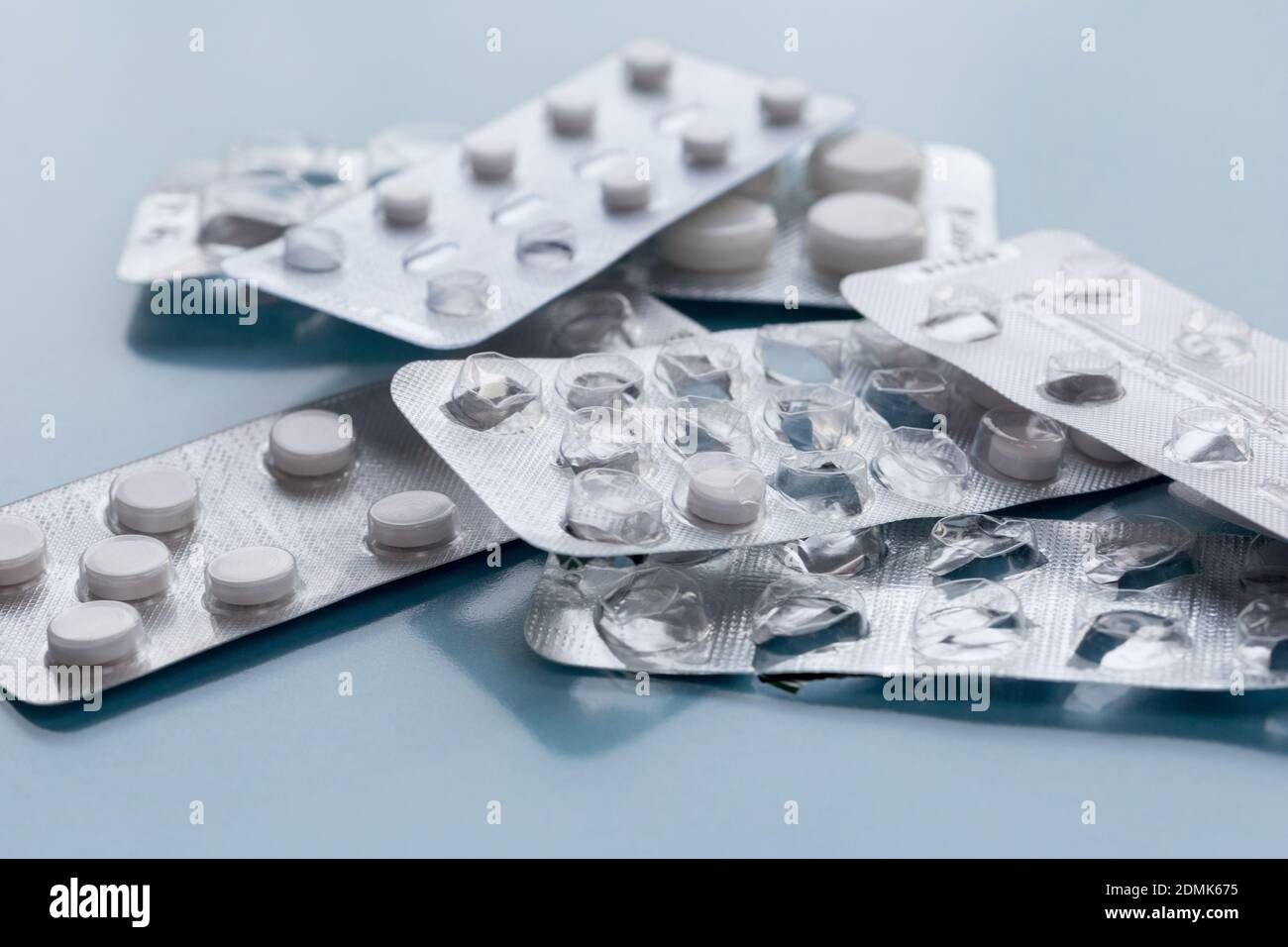 Confezioni di pillole piene e vuote isolate su sfondo blu. Concetto di salute medica o dipendenza da droghe. Copiare spazio per il testo. Foto Stock