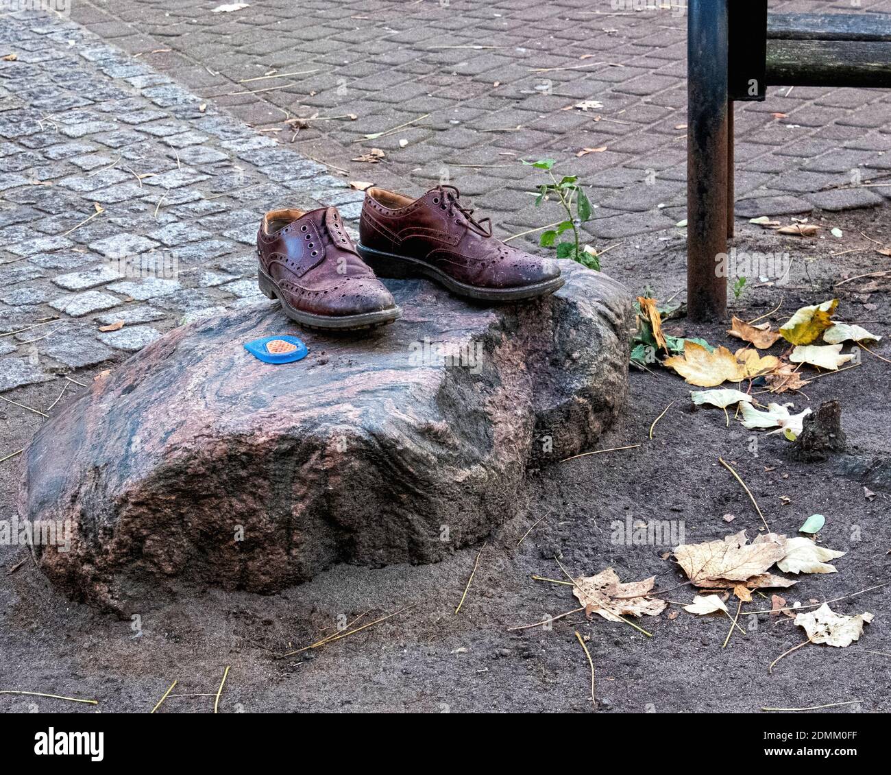 Scarpe in pelle Bown abbandonate o scaricate su una roccia su Teutoburger Platz, Prenzlauer Berg, Berlino, Germania Foto Stock
