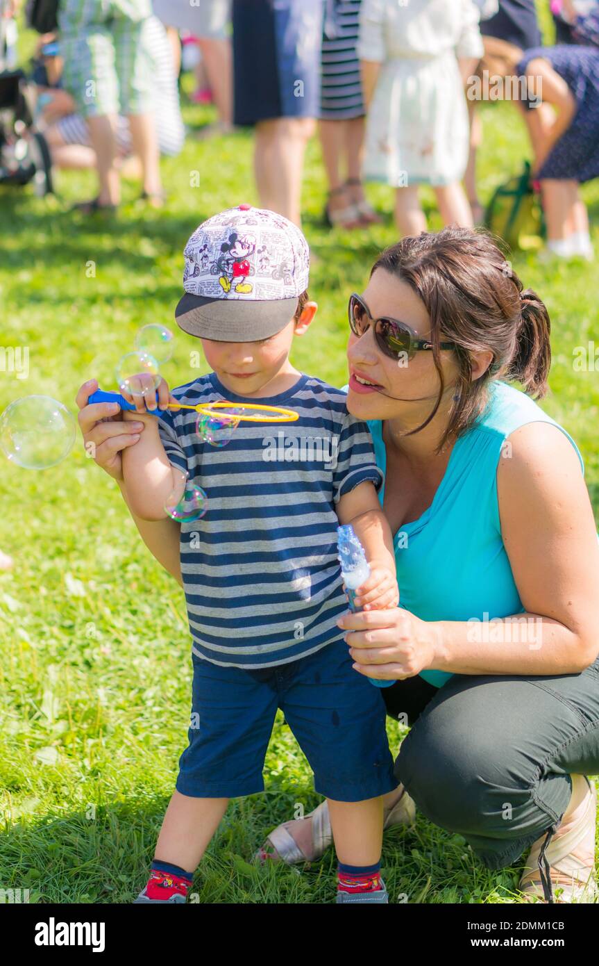 POZNAN, POLONIA - 15 agosto 2017: Donna e bambino con cappello Topolino che  soffia bolle di sapone sul Festiwal Baniek Mydlanych in un parco Foto stock  - Alamy