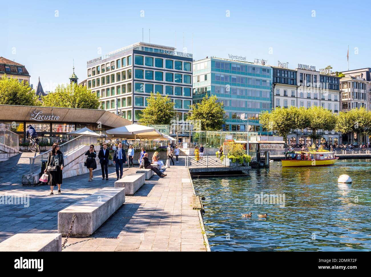Abitanti della città e impiegati che passeggiano sulla banchina del lago di Ginevra. Foto Stock