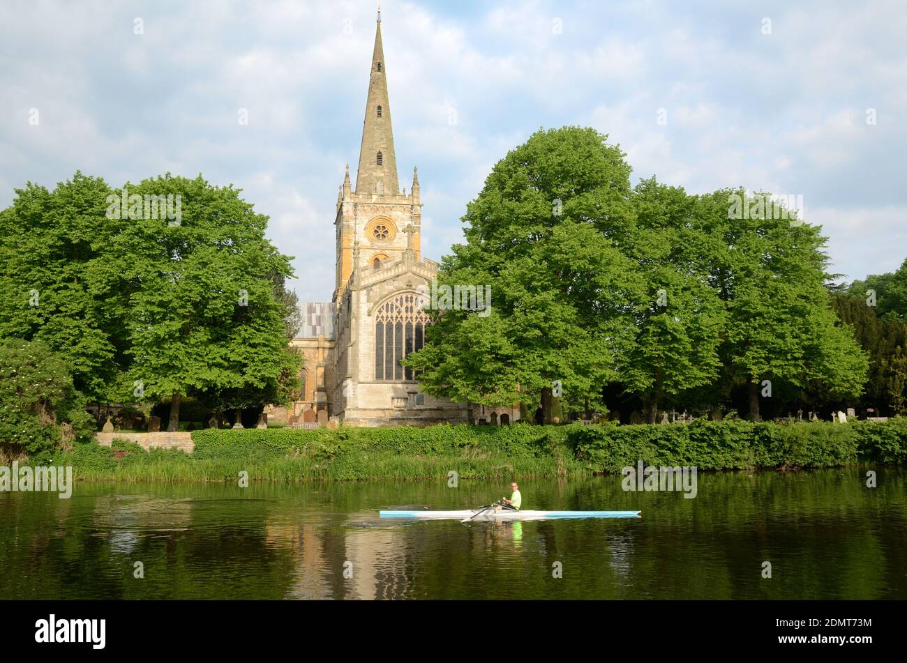 Rower sul fiume Avon Rowing passato la chiesa sepolcrale di Shakespeare, la chiesa commemorativa o la chiesa della Santa Trinità Stratford-upon-Avon Warwickshire Inghilterra Foto Stock