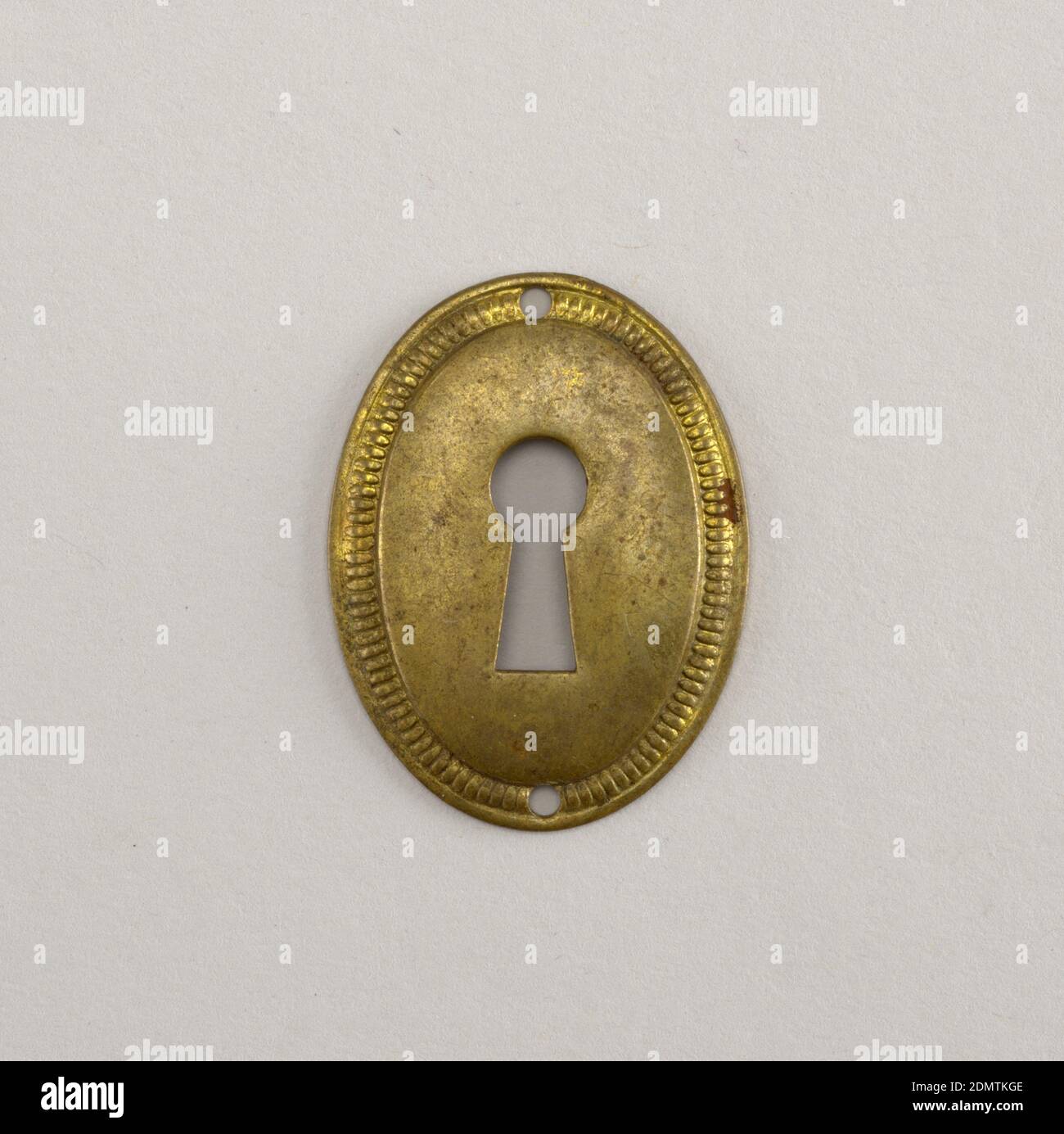 Tombino, Ottone, ovale verticale. Campo convesso, attraverso il quale è trafitto keyhole, circondato da repoussé band., Inghilterra, primi del 19 ° secolo, metallurgia, Arti decorative, Keyhole escutcheon Foto Stock