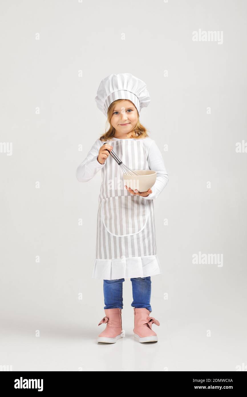 bambina in cappello chef e un grembiule cucina pizza in cucina Foto stock -  Alamy