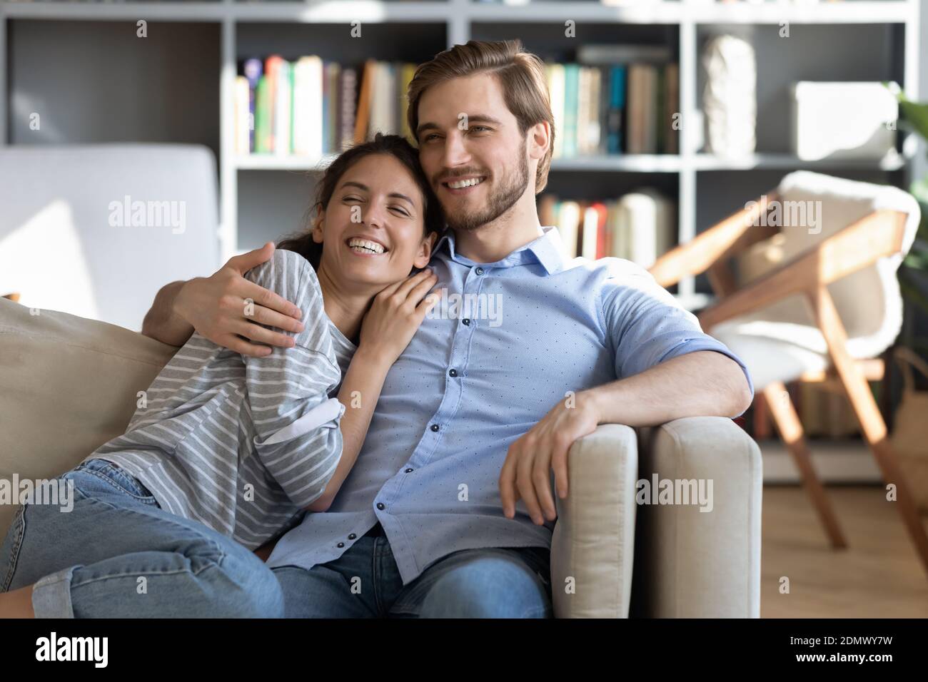 Felice coppia rilassarsi sul divano abbracciando e sognando Foto Stock