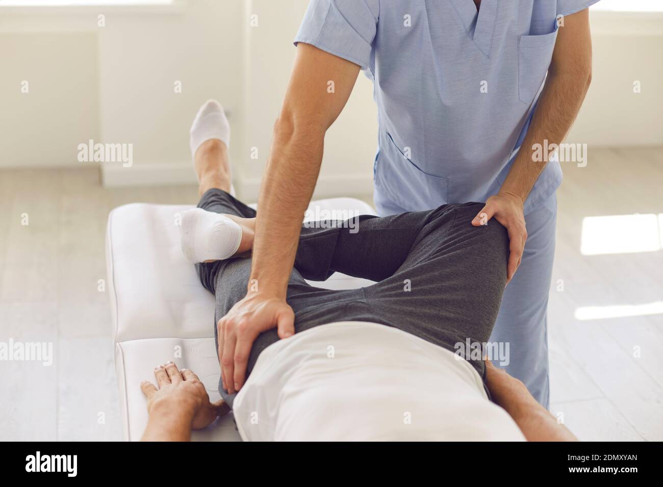 Mani di chiropractor uomo professionale terapeuta manuale fissando i pazienti dell'uomo ossa pelviche Foto Stock