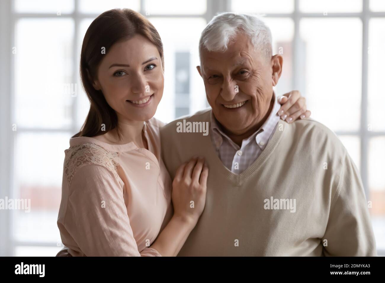 Felice padre anziano e figlia cresciuta abbracciando guardando la macchina fotografica Foto Stock