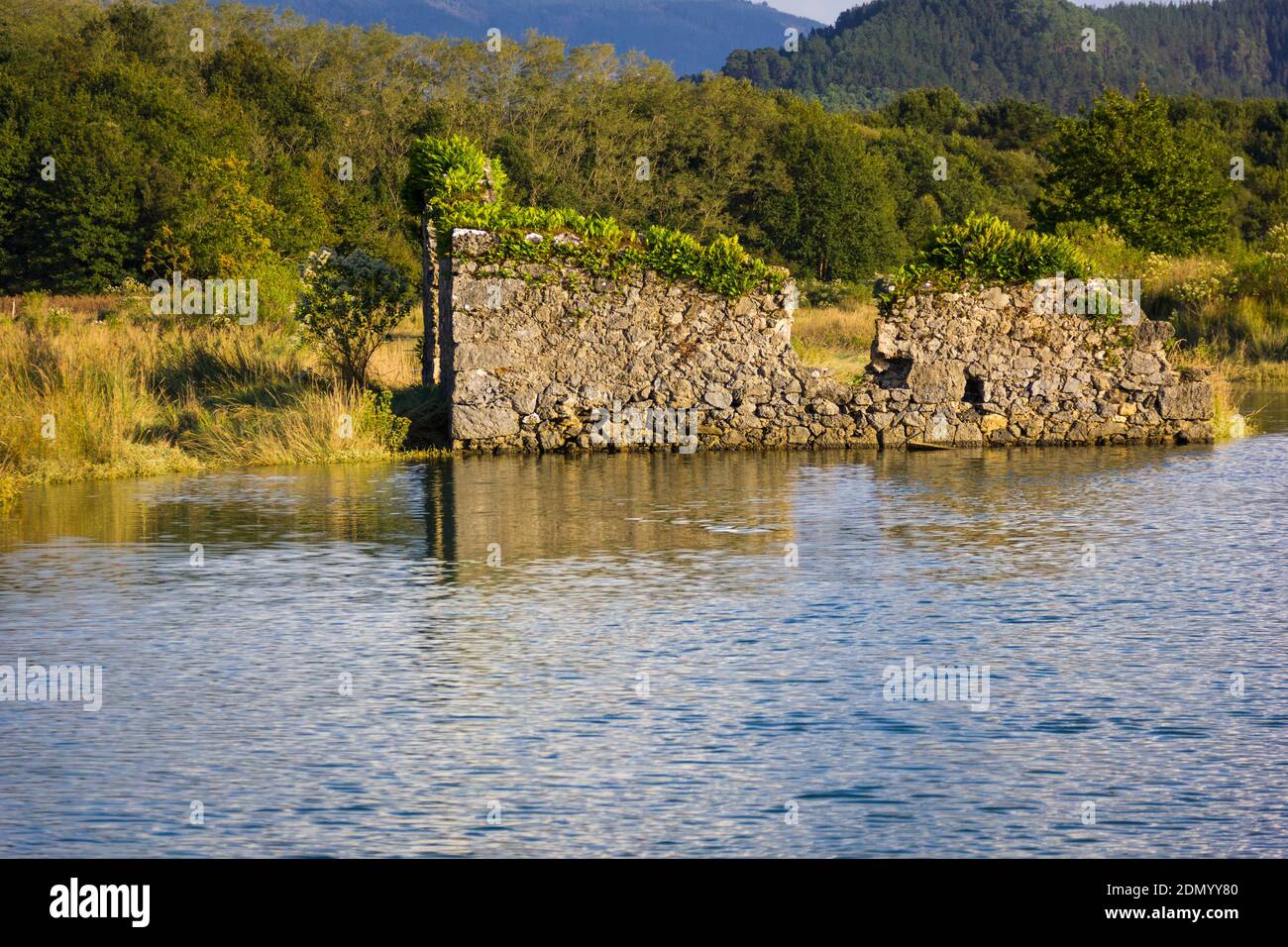 Rovine di vecchio mulino a vento dal fiume nella Riserva Urdaibai Biosfera in giornata di sole. Paesaggio naturale nei Paesi Baschi Foto Stock