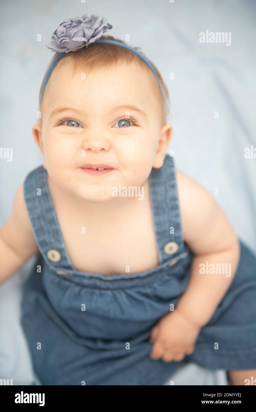 Bambina piccola con gli occhi blu che sorridono alla macchina fotografica Foto Stock