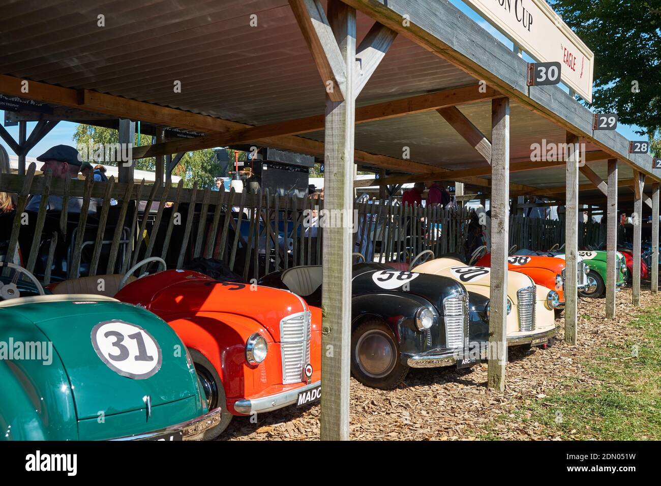 Le pedalò usate nell'evento sprint per bambini aspettano ai box sotto il sole a Goodwood Revival 2019. Foto Stock