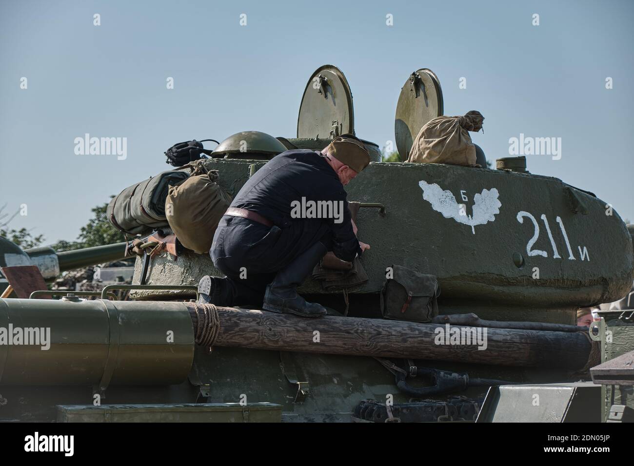 Un crewman russo del carro armato fa fare una certa manutenzione su un La seconda guerra mondiale T34/85 Tank al Tankfest 2019 a Bovington Foto Stock